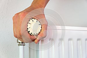 Hand turns heating valve open indoors