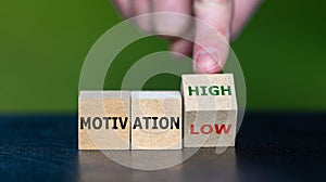Hand turns wooden cube and changes the expression \'motivation low\' to \'motivation high