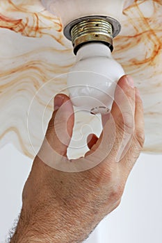 Hand twisting electric light bulb