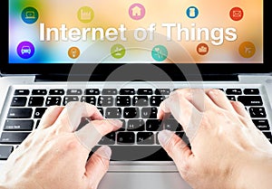 hand type on laptop with Internet of things (IoT) word and object icon and blur background, Digital Marketing concept