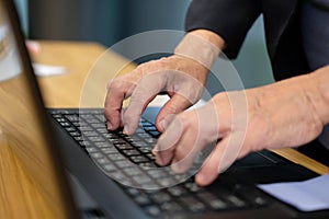 hand typing on computer laptop keyboard working at home office