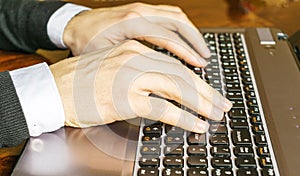 Hand typing on laptop keyboard closeup. Businessman using a laptop computer.