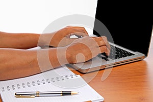 Hand typing a laptop on vintage wooden tables