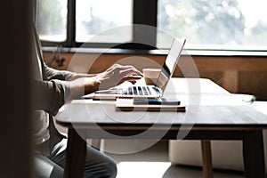 Hand typing message on keyboard laptop chatting friend search information form internet while working on computer