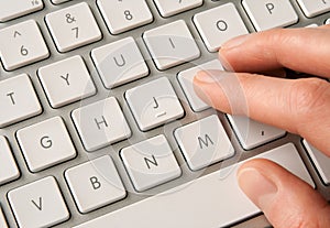 Hand typing on white computer keyboard photo