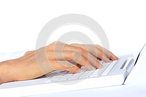 Hand Typing on White Laptop