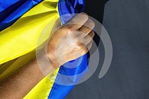 Hand on Ukrainian Flag. The flag of Ukraine is a banner of two equally sized horizontal bands of blue and yellow