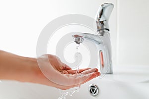 Hand under faucet with water stream