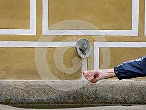 Hand under waterwater spout in europe