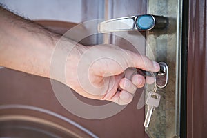 Hand unlocking the door with key