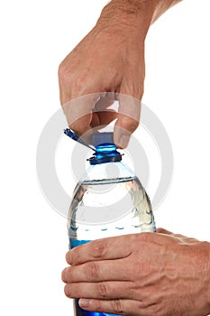 Hand unscrew the cork on a bottle of water photo