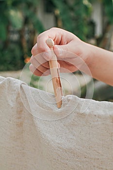 Ã Â¹â¡Hand use clothes pegs hanging fresh clean white towels on drying rack outdoor.Washing day housework with laundry.