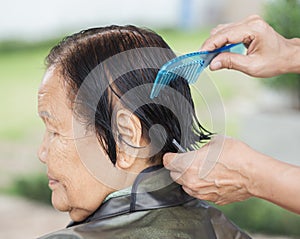 Hand use comb to dressing hair of a senior woman