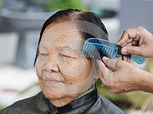 Hand use comb to dressing hair of a senior woman