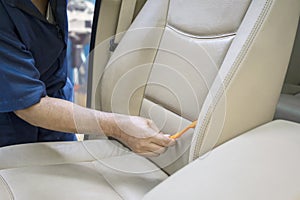 Hand using a brush to clean car seat
