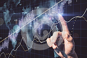 Hand using candlestick chart with digital world map hologram