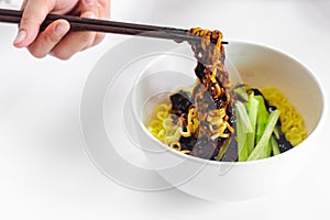 Hand using chopsticks holding Korean Black bean noodle