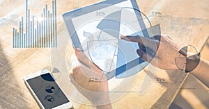 Hand using digital tablet with graphical overlay