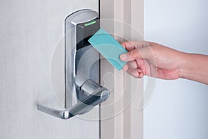 Hand using electronic smart contactless key card for unlock door in hotel or house