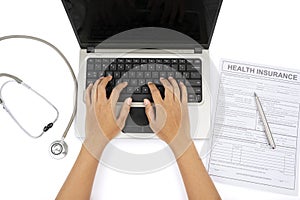 Hand using laptop with health insurance form
