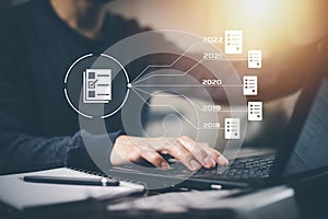 Hand using laptop and touch folder of document Management System, online documentation database and process automation to efficien
