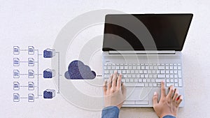 Hand using laptop uploading data to cloud storage system online