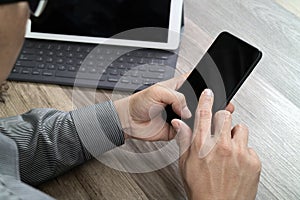 Hand using mobile payments online shopping,omni channel,icon customer network,in modern office wooden desk, blank interface scree