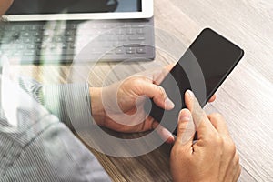 Hand using mobile payments online shopping,omni channel,icon customer network,in modern office wooden desk, blank interface scree