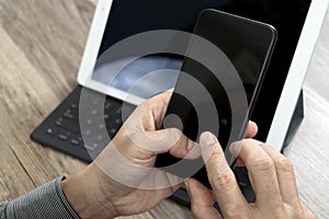 Hand using mobile payments online shopping,omni channel,icon customer network,in modern office wooden desk, blank interface screen