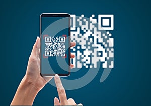 Hand using mobile smart phone scan Qr code on blue background. photo