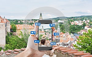 Hand using mobile smart phone taking photo of woman traveling in Cesky krumlov, Czech Republic, with social media