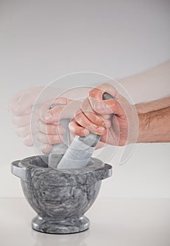 A hand using a mortar and pestle