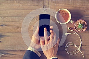 Hand using phone black screen on wooden background