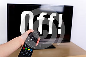 Hand using a remote control to turn off the TV with an OFF text photo