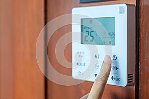 Hand using remote controller for adjust Air conditioner inside the room of hotel or home