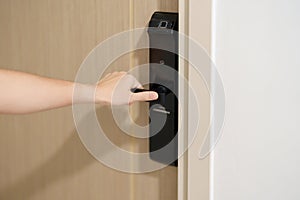 Hand using smart digital door lock while open or close the door at home or apartment. NFC Technology, Fingerprint scan, keycard,
