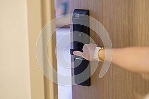 Hand using smart digital door lock while open or close the door at home or apartment. NFC Technology, Fingerprint scan, keycard,