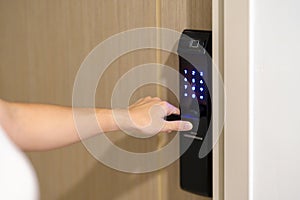 Hand using smart digital door lock while open or close the door at home or apartment. NFC Technology, Fingerprint scan, keycard,