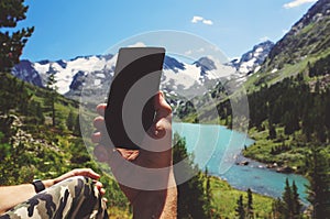 Hand using smartphone on blur landscape view