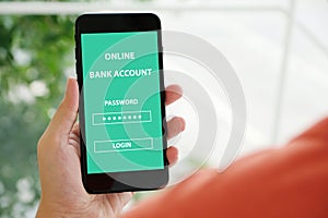 Hand using smartphone with online bank account password login on screen over blur background, online banking cyber security