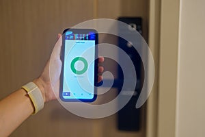 Hand using smartphone for open digital door lock at home or apartment. NFC Technology, Fingerprint scan, keycard, PIN number,