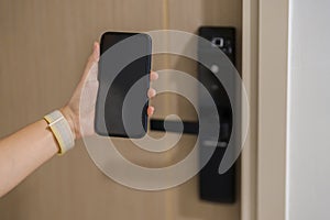 Hand using smartphone for open digital door lock at home or apartment. NFC Technology, Fingerprint scan, keycard, PIN number,