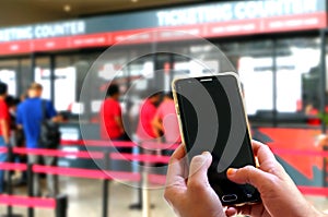 Hand using smartphone at ticketing counters