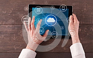 Hand using tablet with centralized cloud computing system concept