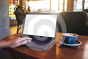 a hand using and touching on laptop computer touchpad with blank white desktop screen in cafe