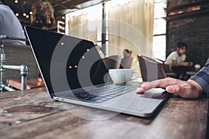 Hand using and touching on laptop touchpad on wooden table