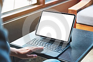 A hand using and touching tablet touchpad with blank white desktop screen as computer pc