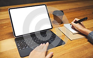 A hand using and touching tablet touchpad with blank white desktop screen as computer pc while writing and working