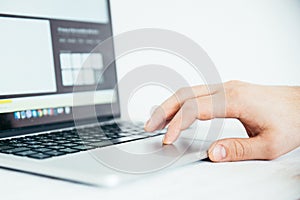 Hand using touchpad on laptop