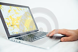 Hand using touchpad on laptop